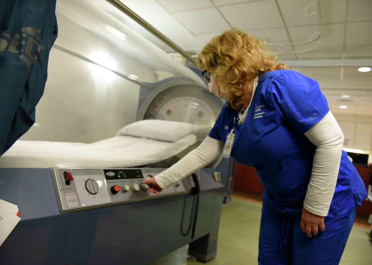 Ellen Stacom, RN, demonstrates the hyperbaric oxygen chamber at Greenwich Hospital in Greenwich, Conn. Thursday, Nov. 5, 2020. Greenwich Hospital will be taking part in a year-long trial that will examine treatment for COVID-19 through the use of hyperbaric oxygen therapy.