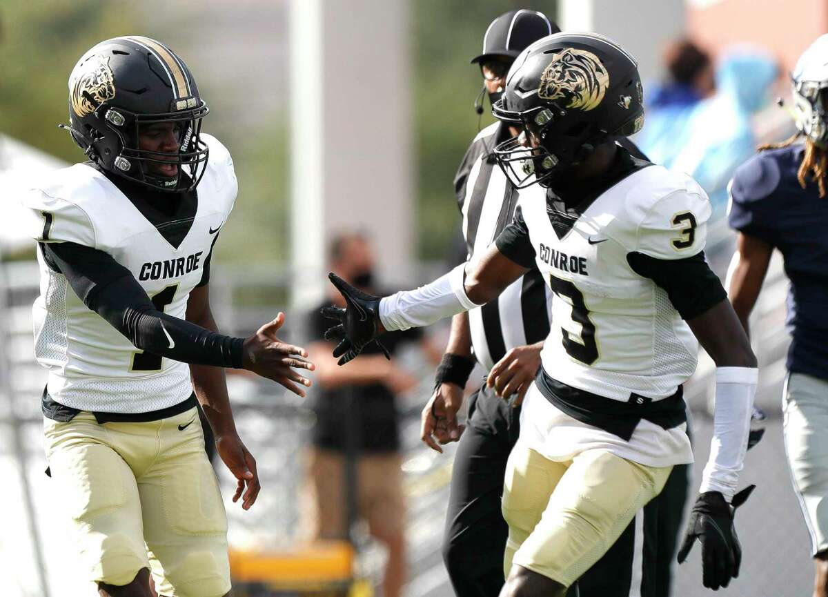 Conroe quarterback Jalen Williams (1) gets a high-five from wide receiver Louis Williams III (3) after running for a 14-yard touchdown during the first quarter of a non-district high school girls basketball game at Oak Ridge High School, Saturday, Nov. 14, 2020.