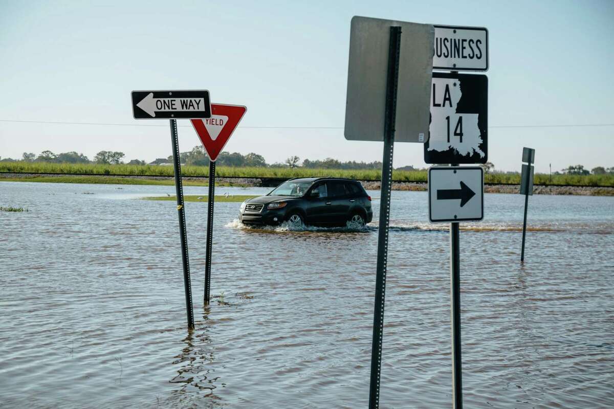 A vehicle drives through floodwater after Hurricane Delta made landfall in Erath, La., on Oct. 10, 2020.