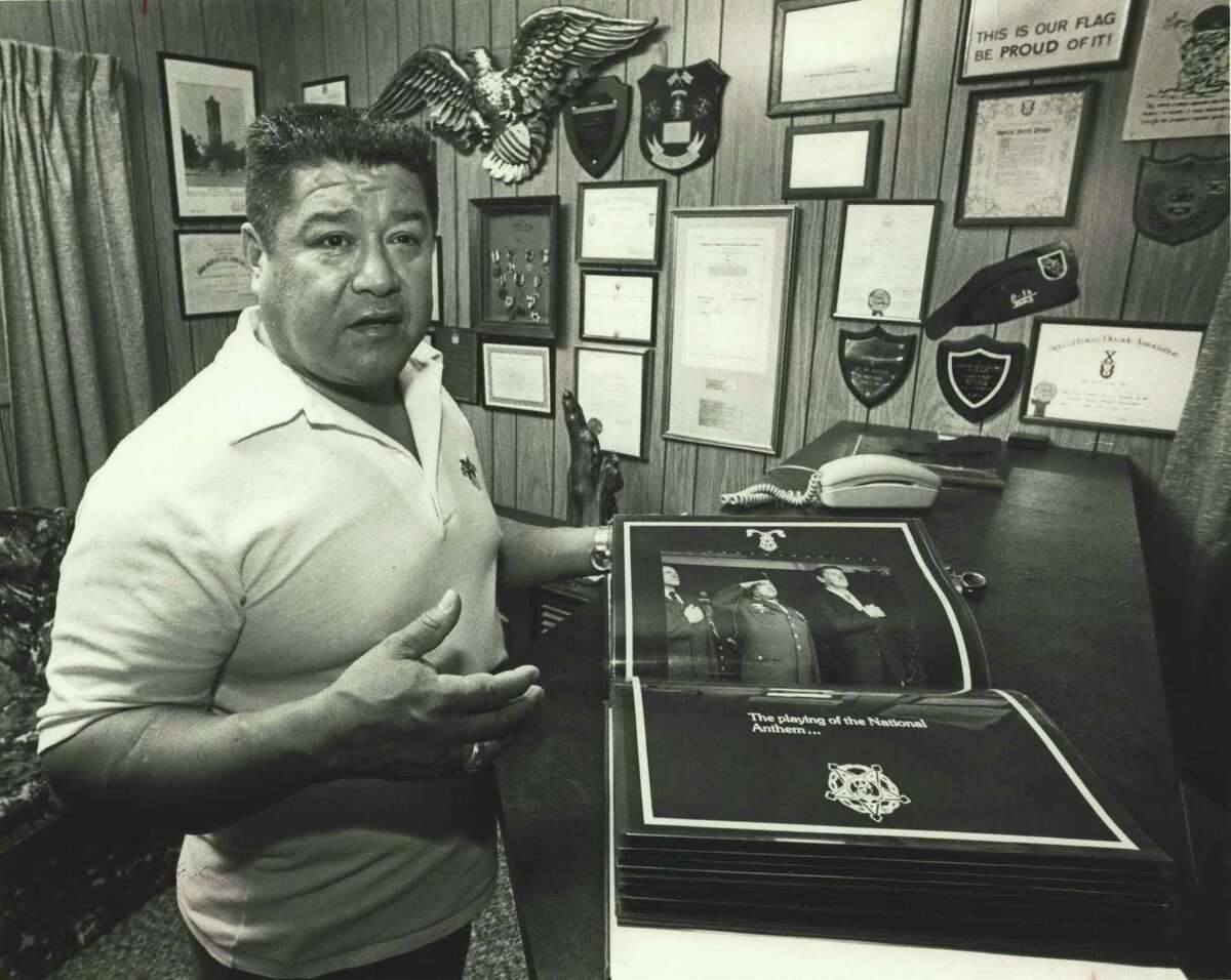 Medal of Honor winner Roy Benavidez looks thru photo album given to him showing awarding of medal of honor and events of that day. His den walls are as decorated as he is; he displays a photo album of his time with the president.