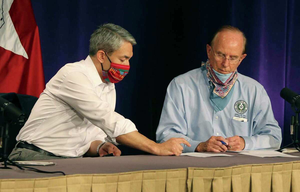 Mayor Ron Nirenberg and Bexar County Judge Nelson Wolff look over information before a city-county briefing on the coronavirus. In nightly coronavirus briefings, Nirenberg has stressed the importance of avoiding large gatherings, wearing masks and practicing physical distancing in the effort to slow the spread of the coronavirus.