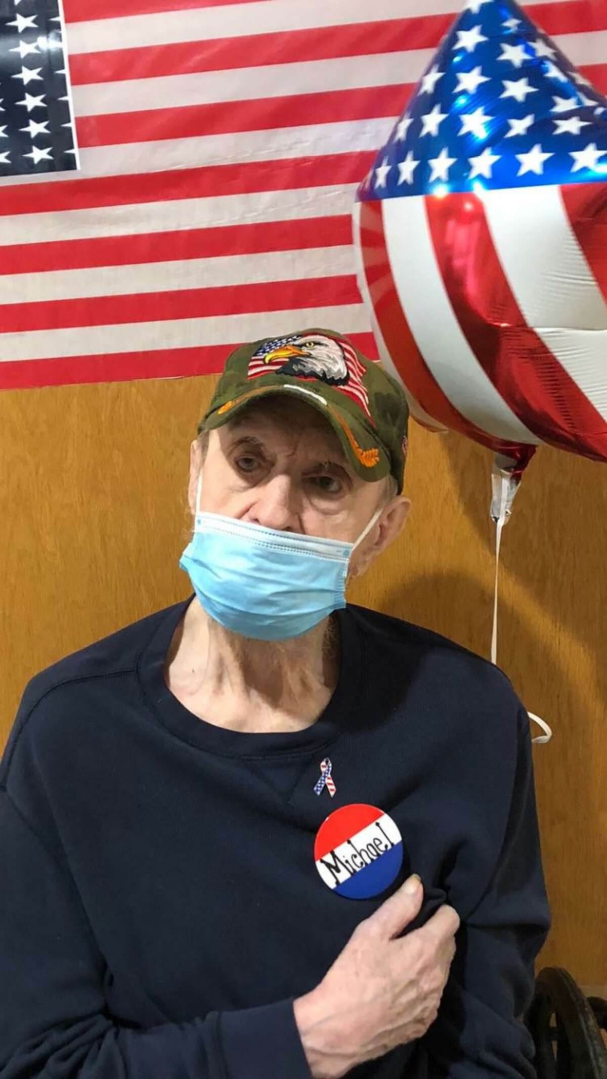 Candlewood Valley Health & Rehabilitation in New Milford recently honored its veterans with gifts. Veterans received a balloon, pins, an American flag and a special dessert. Above, Michael Moran, who served in the field artillery division of the Army, proudly acknowledges his service beneath his mask and alongside a balloon.