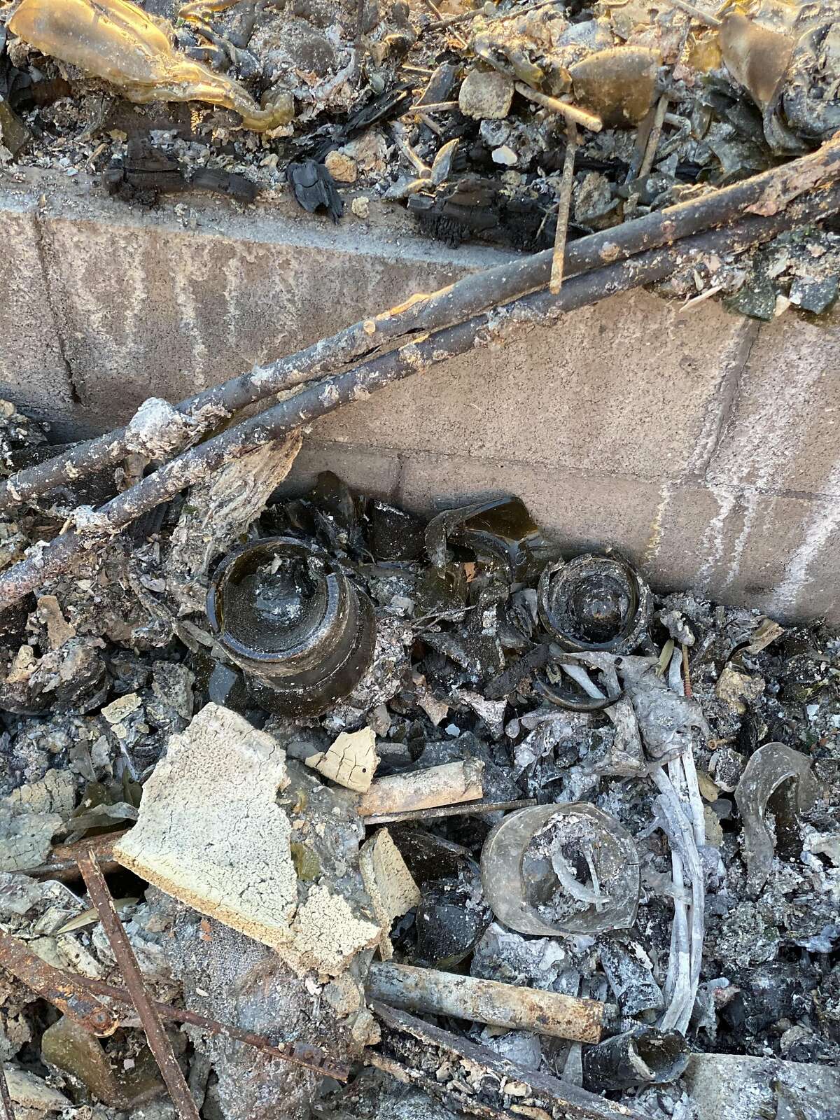Wine bottles are visible in the wreckage from wine writer Jess Lander's home in Napa, which was destroyed by the Glass Fire.