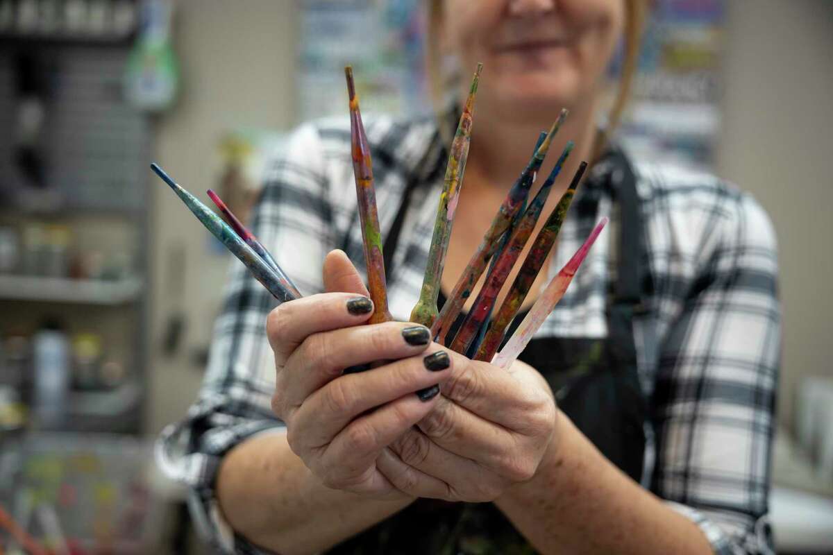 Toria Hill holds her favorite painting instrument, pipettes, in her studio at her home, Thursday, Nov. 12, 2020, in Willis. Hill plans to showcase at least 20 pieces for a show in 2021.