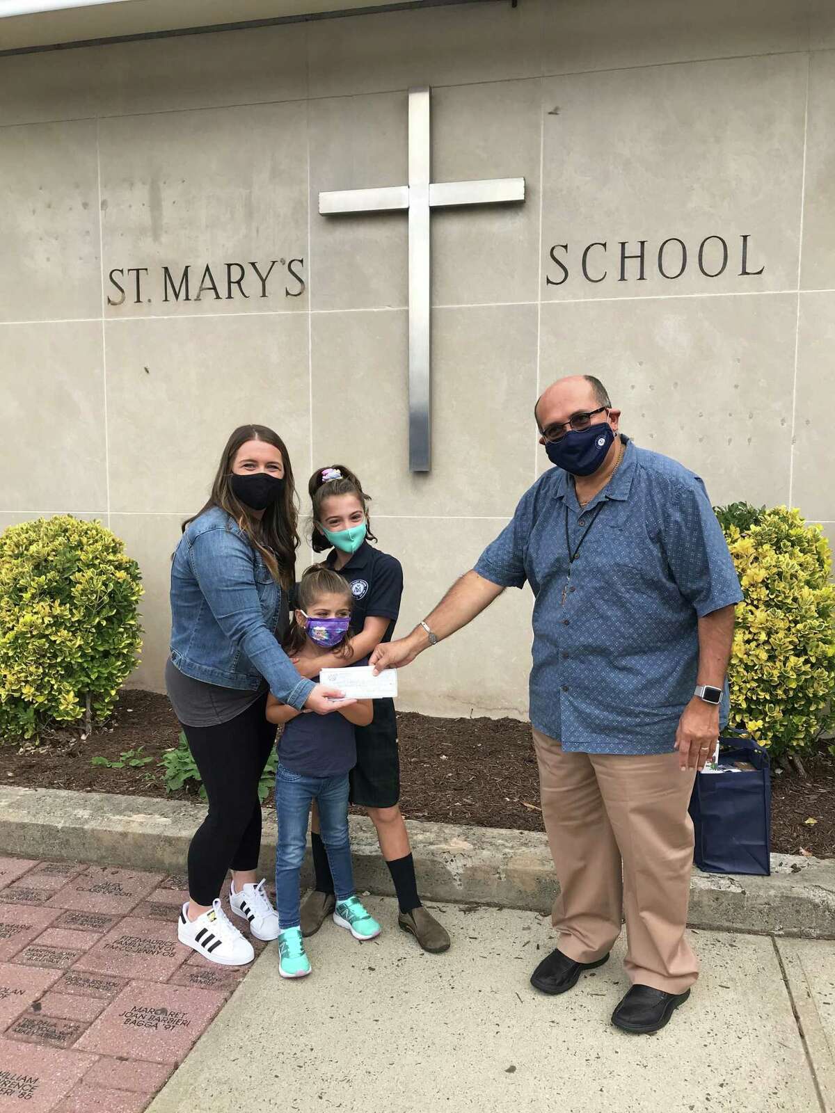 St. Mary School in Milford thanked their friends at Jimmy's Apizza for supporting their school at the fourth annual SMS Family Pizza Night, Curbside Edition. A portion of the night's sales and raffle proceeds totaling more than $1,000 were donated to the school. Jimmy and Sue Ormrod, the Hogan family, the hard workers at Jimmys and everyone who bought dinner to support the event were thanked by the school. A preschooler Cooper won the raffle basket. Pictured is Danielle Hogan with daughters Brooklyn and Devyn presenting the check to Principal Deacon Dominic Corraro.