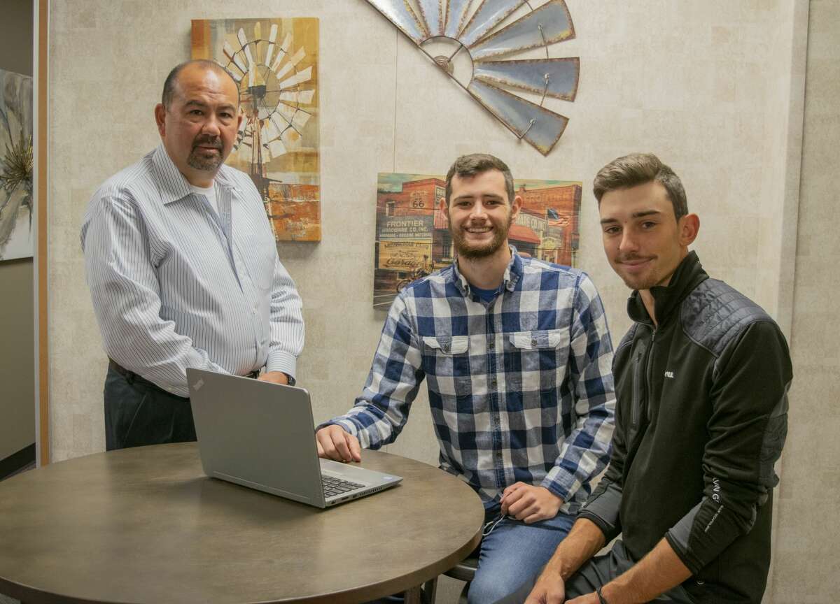 Jason Geesey, from left, worked with students Jonathan Darnell and Sebastien Tremulot on the global Business Strategy Game this semester. Darnell and Tremulot finished the game with a No. 1 overall ranking.