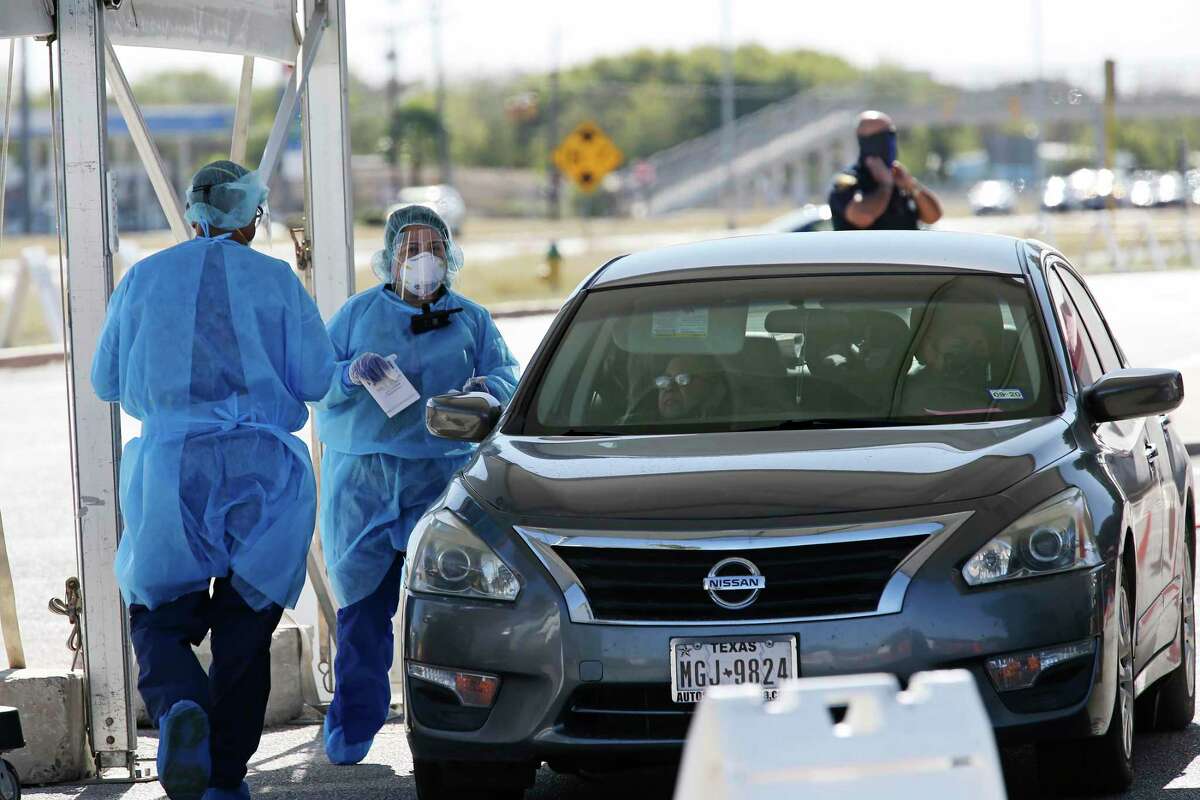 Personnel prepare to test a woman at a COVID-19 drive through testing site at a CentroMed Clinic on Palo Alto Road, Monday, Nov. 16, 2020.