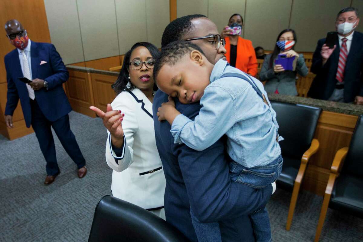Josiah Babalola, 4, lays his head on the shoulder of his father, Samson, after his mother, Teneshia Hudspeth, left, was sworn in as the new Harris County Clerk Tuesday, Nov. 17, 2020 in Houston. Hudspeth is Harris County's first African American county clerk.