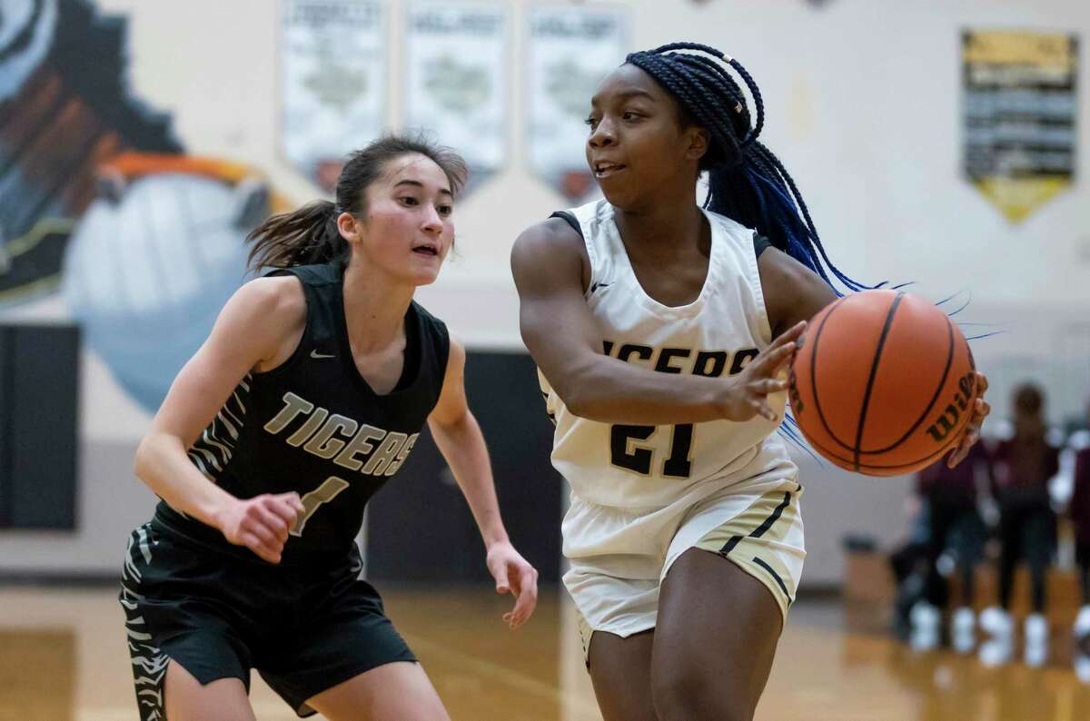 Conroe sophomore Miya Evans (21) passes the ball while under pressure by A&M Consolidated Sarah Hathorn (1) during the third quarter of a non-district high school basketball game at Conroe High School, Tuesday, Nov. 17, 2020, in Conroe.