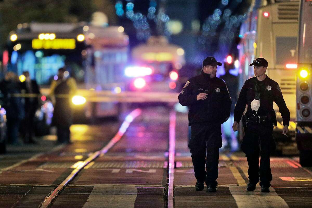 Investigators look over the scene of a police shooting on Market Street outside the Powell Street Bart Station and Westfield Shopping Center in San Francisco, Calif., on Tuesday, November 17, 2020.