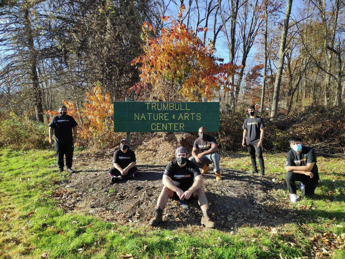 Recently, employees of the Amazon Trumbull Distribution Center volunteered at the Trumbull Nature & Arts Center (TNAC), located across the street from their facility at 7115 Main St. The group raked and blew leaves from under the large maple tree in front of the TNAC building and cut down the sunflowers for the season to help prepare the grounds for the winter season.