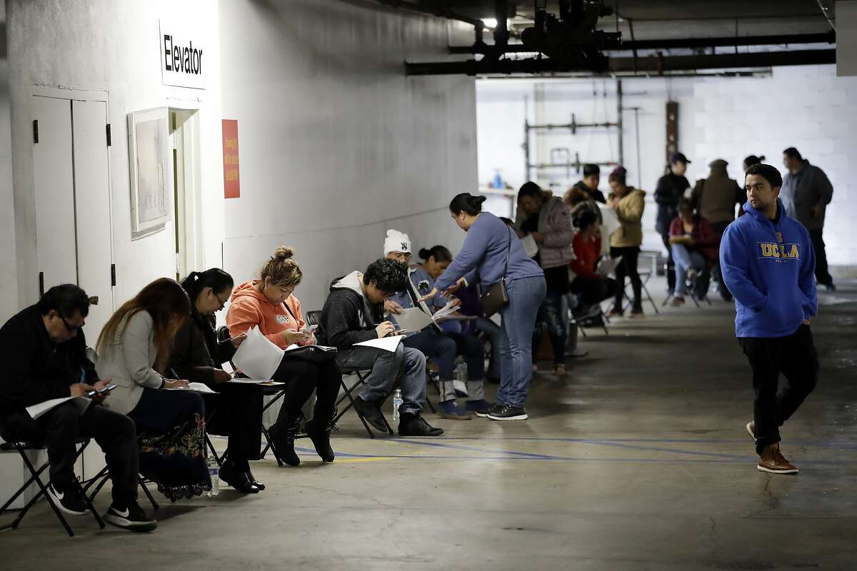 In this March 13, 2020, file photo, unionized hospitality workers wait in line in a basement garage to apply for unemployment benefits at the Hospitality Training Academy in Los Angeles. California's unemployment rate nearly tripled in April because of the economic fallout from coronavirus pandemic.