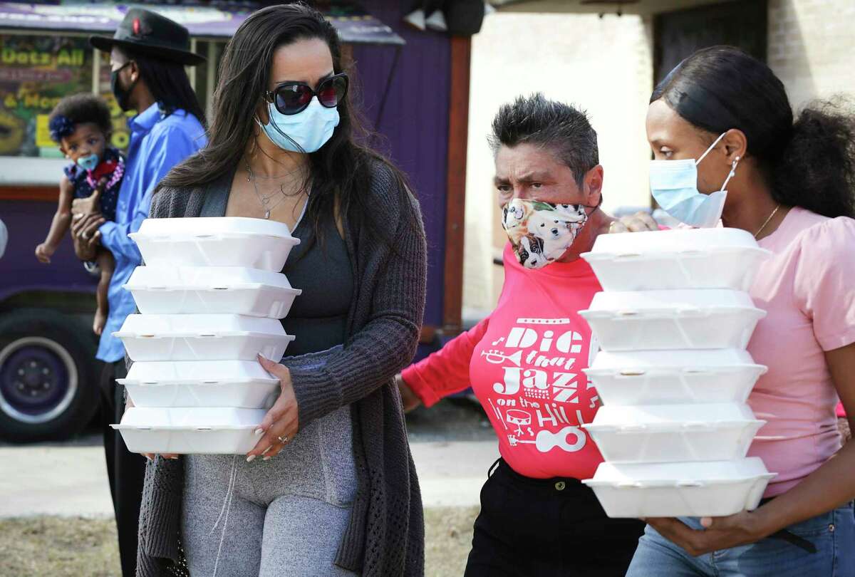 Liz Franklin, center, assists Josey Garcia, left, and Krystal Haywood, right, who will be delivering Thanksgiving meals in the Martin Luther King Dr. area. WestCare Texas, Ella Austin Community Center, South Texas Blood and Tissue Center, Amerigroup, HEB and others offer services including Thanksgiving meals and free flu shots at the east side Community Center on Wednesday, Nov. 18, 2020.
