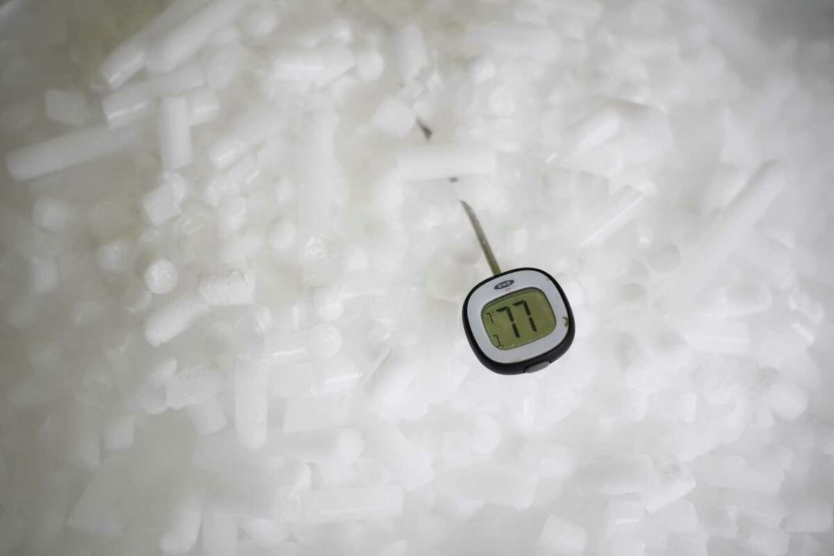 READING, ENGLAND - NOVEMBER 11: A thermometer displays a temperature of -77 degrees centigrade as it rests in a supply of coarse dry ice pellets at the Dry Ice Nationwide manufacturing facility on November 11, 2020 in Reading, England. Producing dry ice in a number of forms, the company provides both coarse pellets and slabs for use in temperature-controlled pharmaceutical logistics, pathological environments and chemical laboratories, as well as for food transportation. The covid-19 vaccine developed by Pfizer and BioNTech must be kept at ultra-cold temperatures in its journey from the production line to a patient's arm. To address this challenge, Pfizer developed a suitcase-sized box that uses dry ice to keep between 1,000 and 5,000 doses for 10 days at minus 70 degrees Celsius. (Photo by Leon Neal/Getty Images)