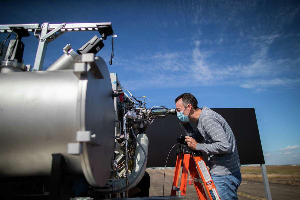 Intuitive Machines senior propulsion engineer Rob Morehead takes a look inside a rocket engine’s nozzle looking for anomalies caused during the combustion of super-cold liquid oxygen and liquid methane during a test, Thursday, Nov. 5, 2020, in Houston.