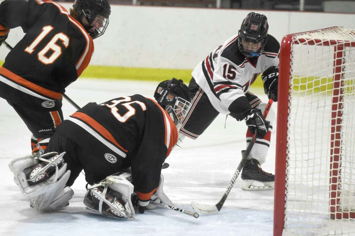 Ridgefield goalie Matthew Silliman stops the puck after a shot by New Canaan’s Nick Megdanis (15) during the FCIAC boys ice hockey semifnals at the Darien Ice House on March 4.