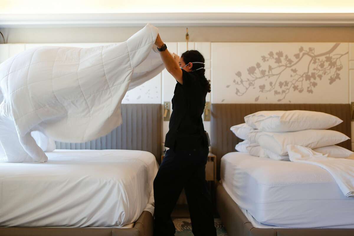 Housekeeper Brenda Vallejo makes a bed in one of the few occupied rooms at Hotel Nikko near Union Square in San Francisco.