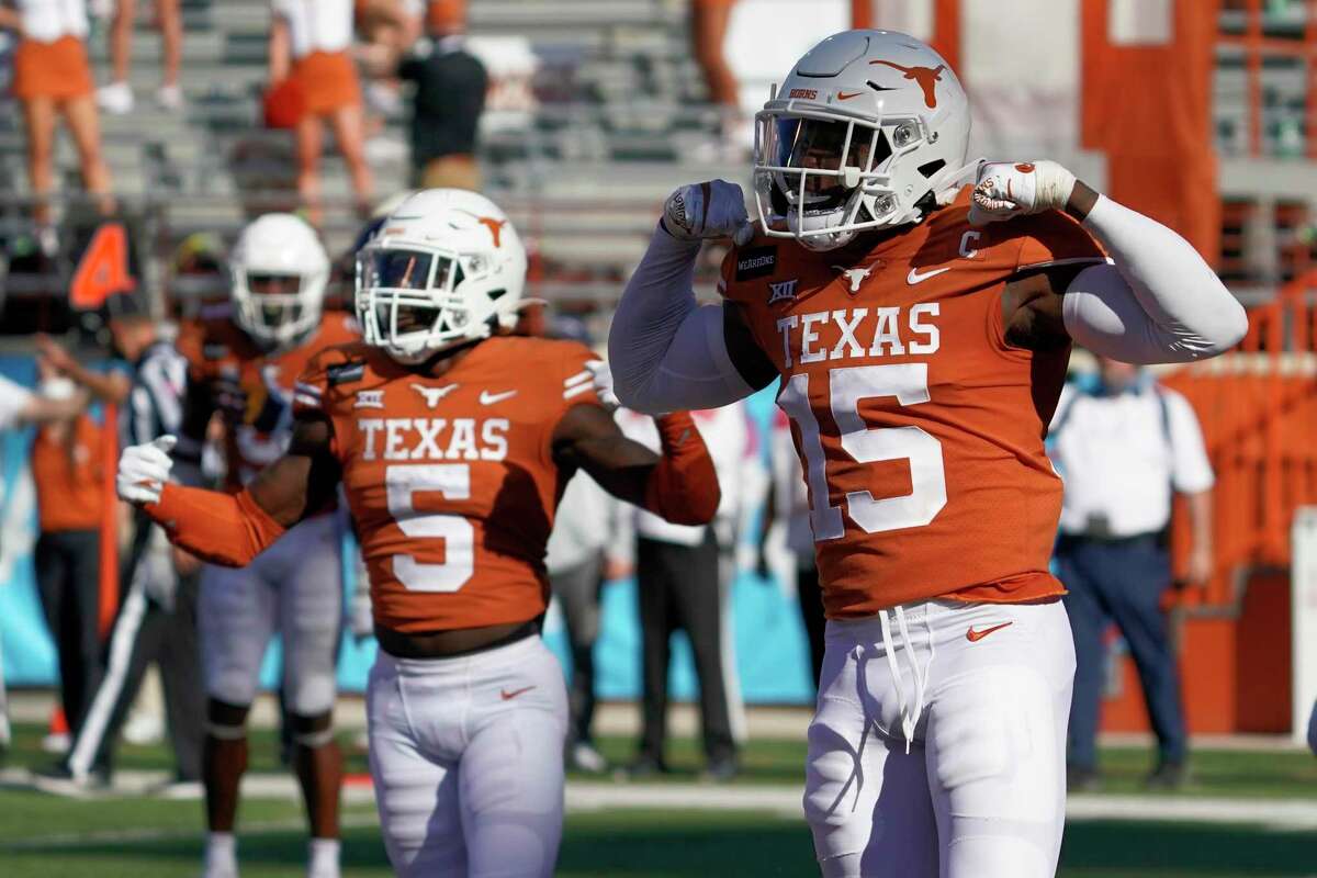 Texas' Chris Brown (15) and D'Shawn Jamison (5) celebrates after a stop against West Virginia on fourth down late during the second half of an NCAA college football game in Austin, Texas, Saturday, Nov. 7, 2020. (AP Photo/Chuck Burton)