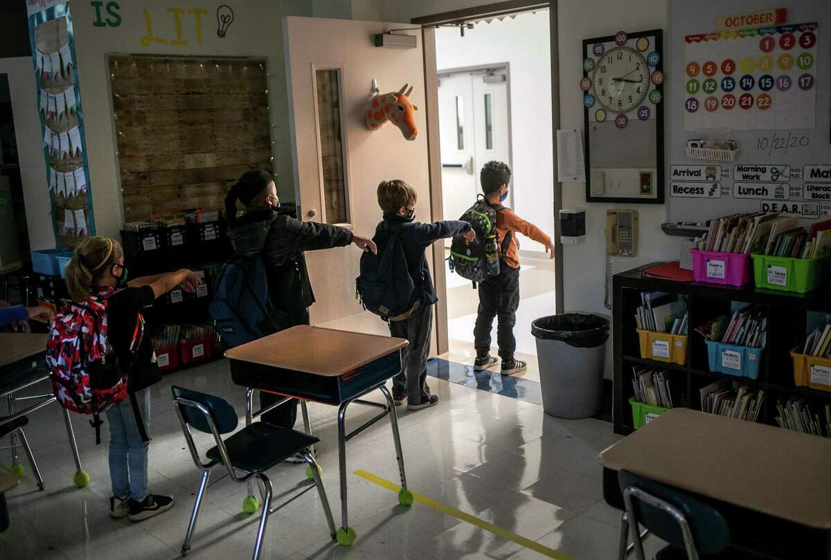 A kindergarten class socially distances while preparing to leave their classroom at Stark Elementary School on October 21, 2020 in Stamford, Connecticut. Stamford Public Schools is continuing the fall semester with a hybrid model of in-class and distance learning, occasionally quarantining individual classes when a student or faculty member tests positive for COVID-19.