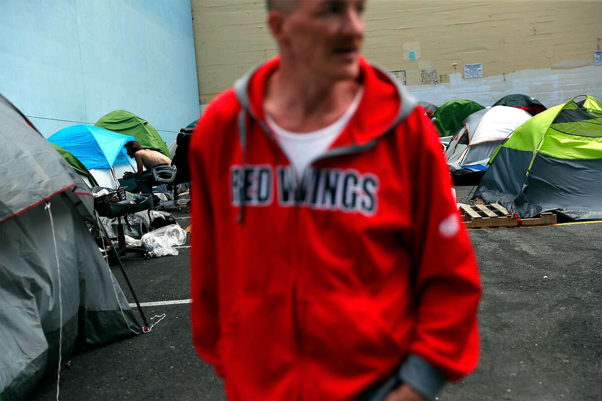 Richard van Dusen stands outside his tent in the parking lot at 180 Jones St. in San Francisco in June.