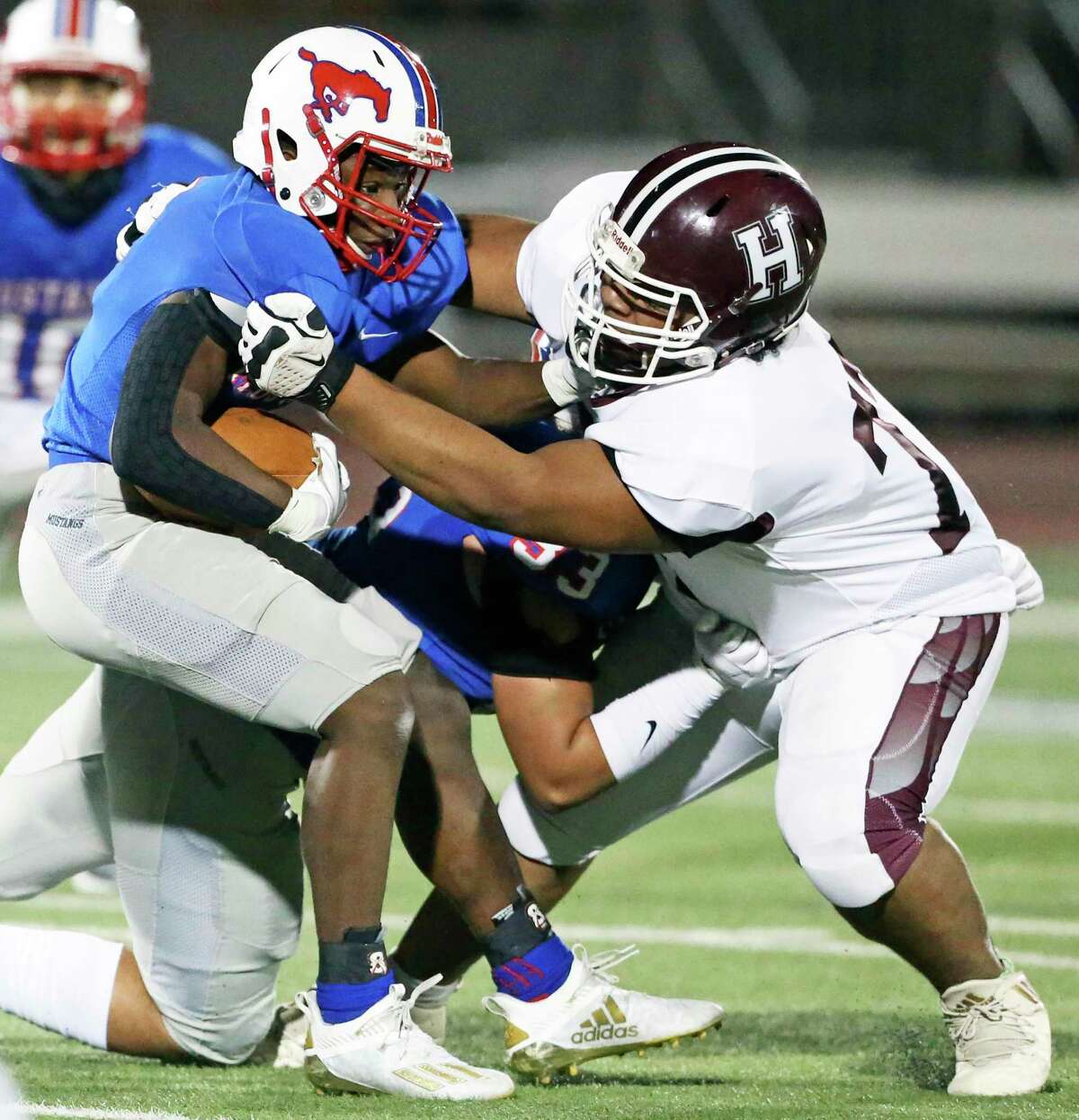 The Mustangs' Albert Slaughter is brought down by Owl defensive end Michael Flores as Highlands plays Jefferson in high school football at Alamo Stadium on Nov. 19, 2020