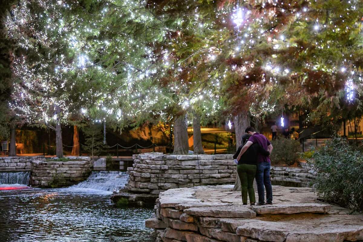 Badr and Nahar Harfouch share a moment under the Christmas lights on the San Antonio River on the Mission Reach near The Pearl on Wednesday, Nov. 18, 2020.