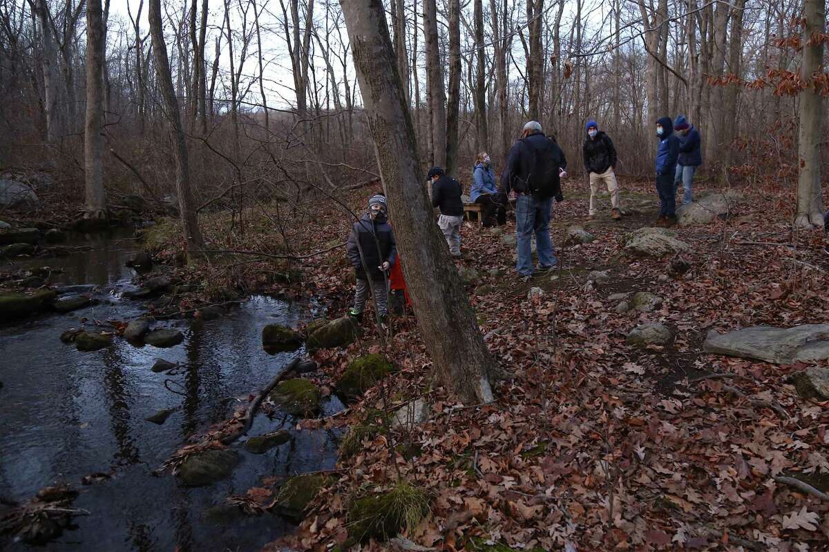 Participants enjoy a moment at an area known as the Secret Stream at Woodcock Nature Center in Wilton, Conn. at one of the nature cetner's fall activities about a sunset hike in a previous year. The nature center has registration open for programming it is offering over Wilton Public Schools' spring break, April 5 through April 8.