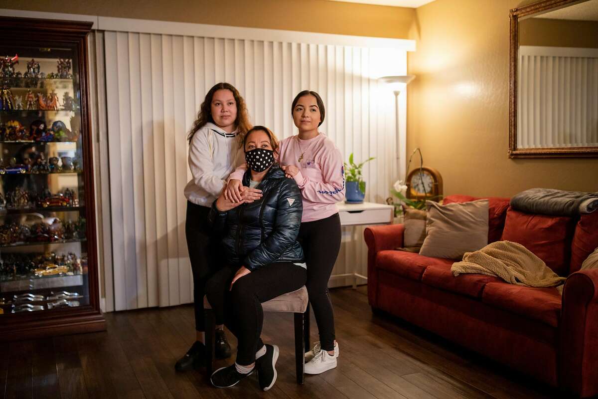 Aurelia Vargas (center) with her daughters Dulce Solis, 12, (left) and Ailyn Martinez, 16, at their home on Friday, Nov. 20, 2020, in San Rafael, Calif. Vargas was diagnosed with the novel coronavirus in July. She experienced COVID-19 symptoms for almost a month. Vargas was worried he had transmitted the virus to her family. Her family tested negative.
