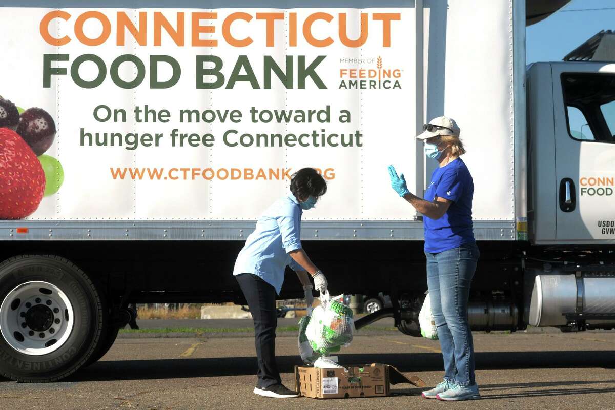 All proceeds from St. Andrew's Lutheran Church's tag sale Saturday, Nov. 21, are going to be used to benefit hunger agencies in Connecticut including the Connecticut Food Bank. Volunteers Ann Kim, left, of Wilton, and Claire Schoen, of Norwalk, handle frozen turkeys during Connecticut Food Bank's drive-thru turkey distribution in Veteran's Memorial Park, in Norwalk, Nov. 9.