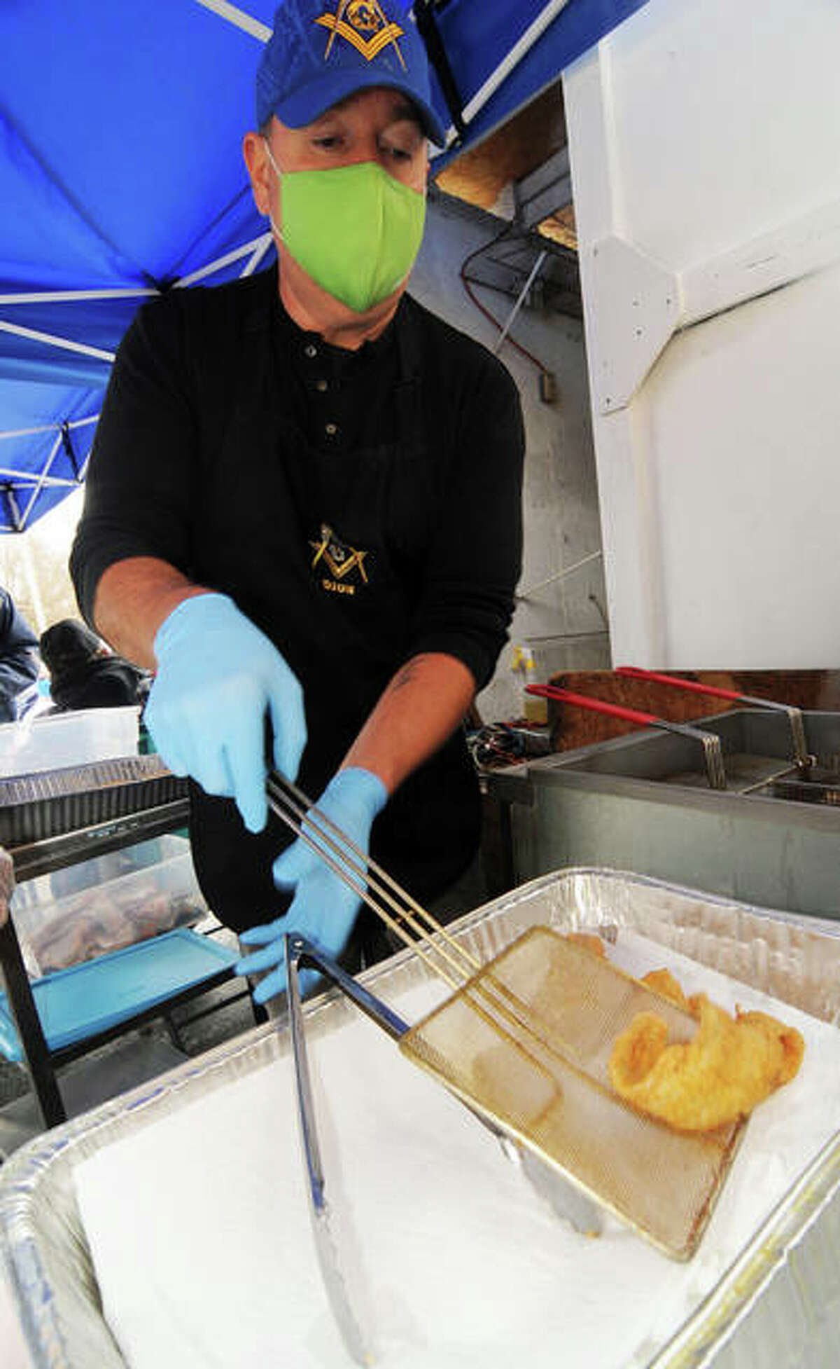 Dion Roe removes a hot piece of fish from the fryer during Saturday’s Bethalto Masonic Lodge Fish Fry.