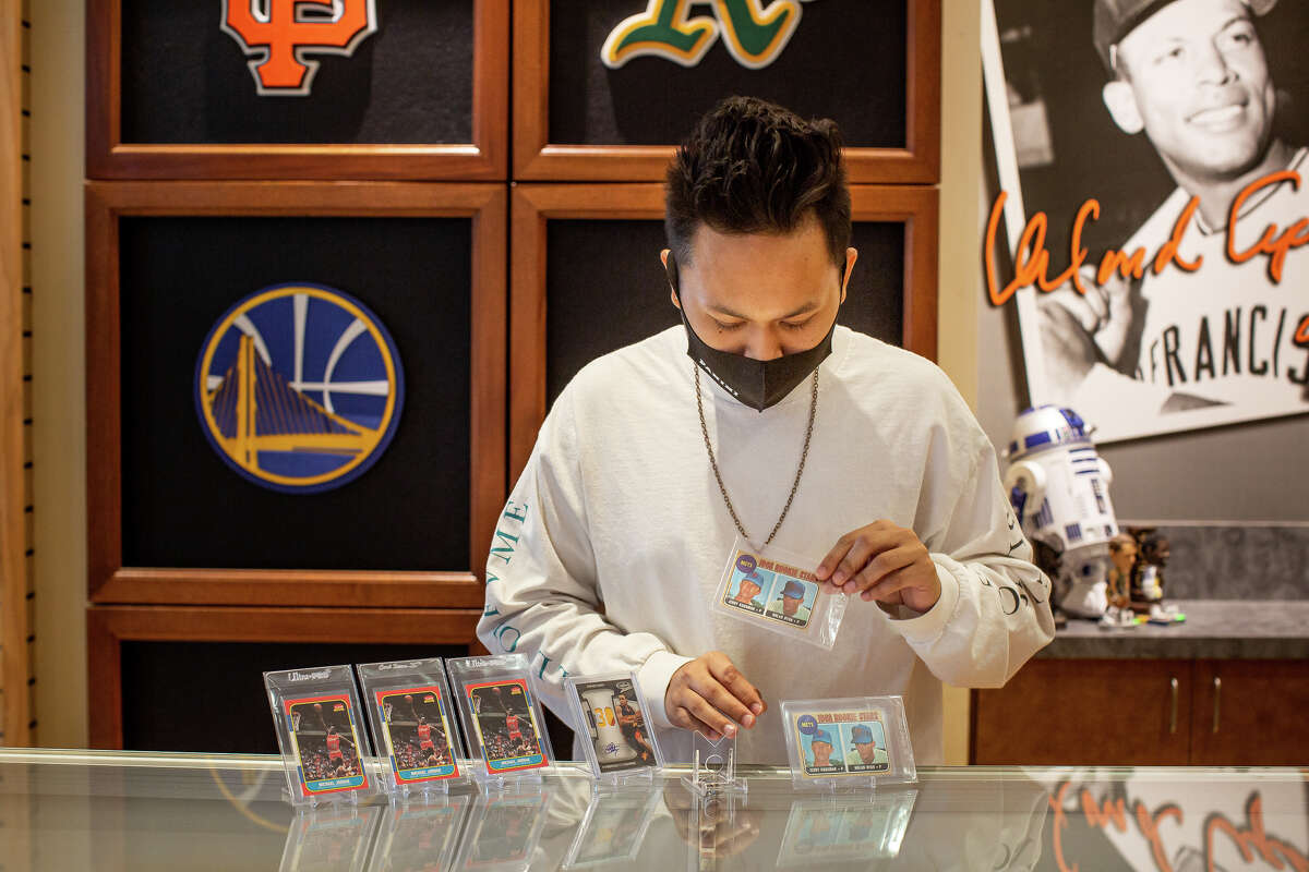 Classic Materials Sports & Collectibles store owner Rey Reyes examines trading cards.