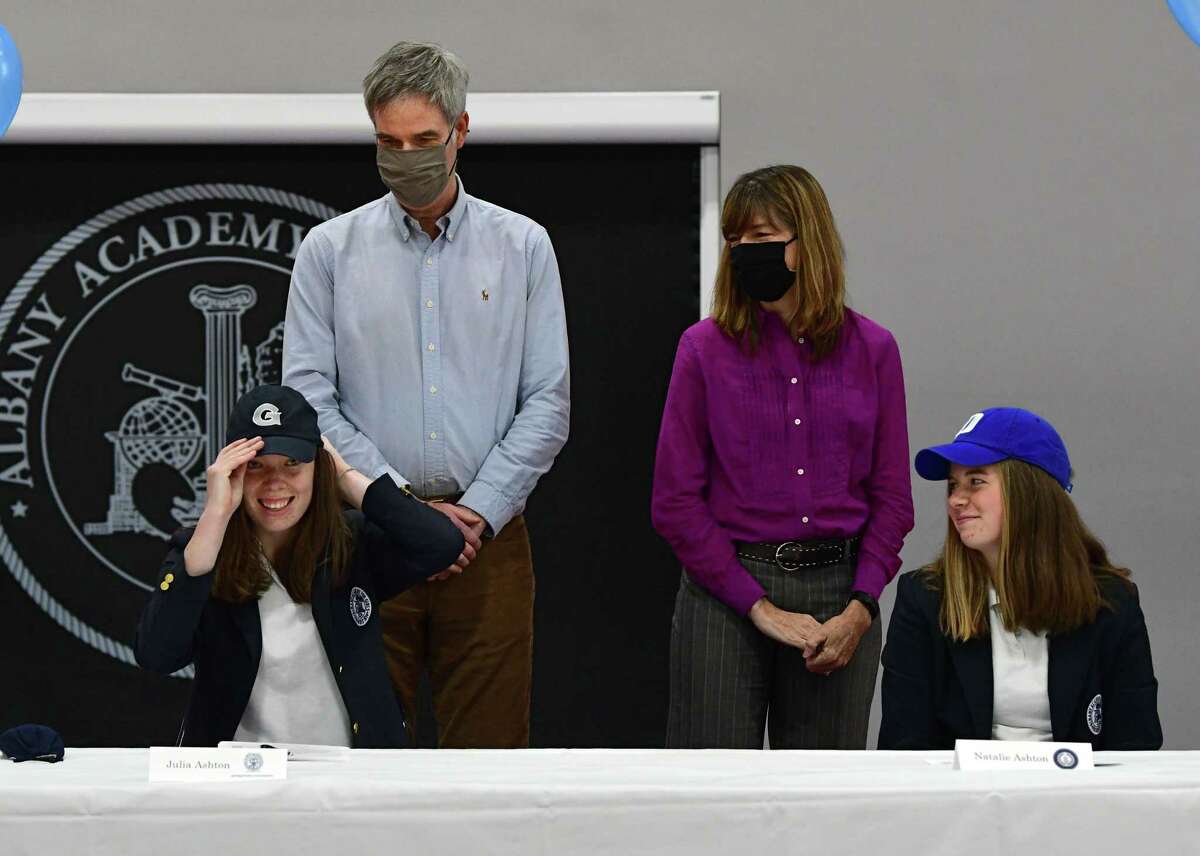 Albany Academy rower Julia Ashton puts on a Georgetown hat after signing a letter of intent for Georgetown University during a college signing ceremony at Albany Academy on Monday, Nov. 23, 2020 in Albany, N.Y. Natalie's sister Natalie, who was signing to row at Duke, sits next to her at right. (Lori Van Buren/Times Union)