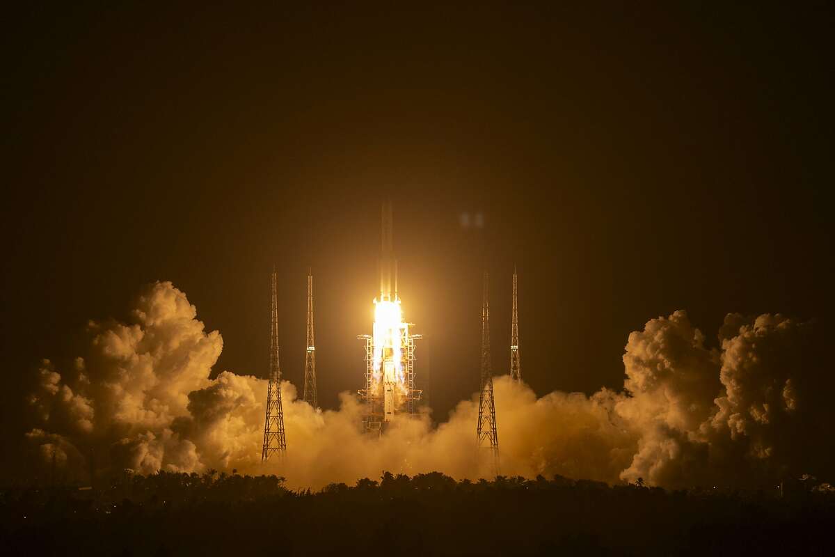 A Long March-5 rocket carrying the Chang'e 5 lunar mission lifts off at the Wenchang Space Launch Center in Wenchang in southern China's Hainan Province, early Tuesday, Nov. 24, 2020. (AP Photo/Mark Schiefelbein)