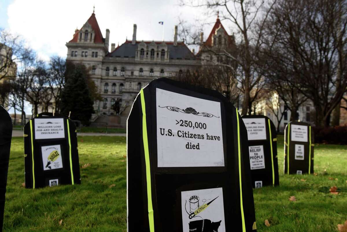 Symbolic tombstones representing the social impacts of coronavirus are placed in West Capitol Park during a Poor People's Campaign stop at the Capitol on Monday, Nov. 23, 2020, in Albany, N.Y. Citizen Action of New York led the Capital Region segment of nationwide event held at state capitols to mourn the nearly quarter-million Americans who died from COVID-19. Organizers are calling for a just recovery from state and national leaders. (Will Waldron/Times Union)