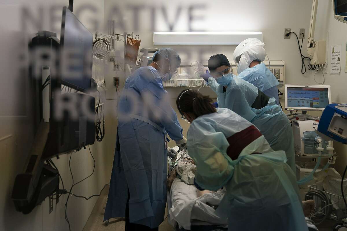 EMT Giselle Dorgalli, second from right, looks at a monitor while performing chest compression on a patient who tested positive for coronavirus in the emergency room at Providence Holy Cross Medical Center in the Mission Hills section of Los Angeles, Thursday, Nov. 19, 2020. California is imposing an overnight curfew on most residents as the most populous state tries to head off a surge in coronavirus cases that it fears could tax its health care system, Gov. Gavin Newsom announced Thursday. (AP Photo/Jae C. Hong)