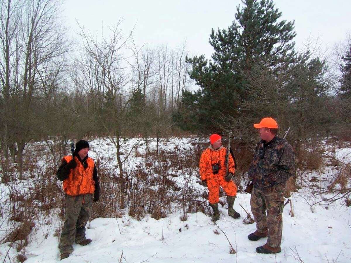 Hunters compare notes at the end of a late-season deer drive. (Photo provided/Tom Lounsbury/Hearst Michigan)
