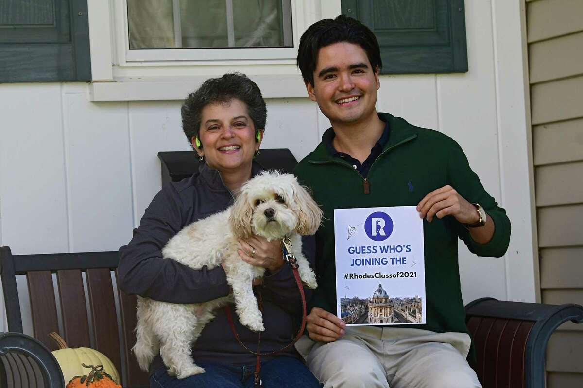 Lynell Engelmyer, holding her dog Bailey, sits next to Santiago Potes who learned over the weekend that he had received the prestigious Rhodes Scholarship on Tuesday, Nov. 24, 2020 in Niskayuna, N.Y. Potes has been staying with the Engelmyer family in Niskayuna for the past few months. (Lori Van Buren/Times Union)