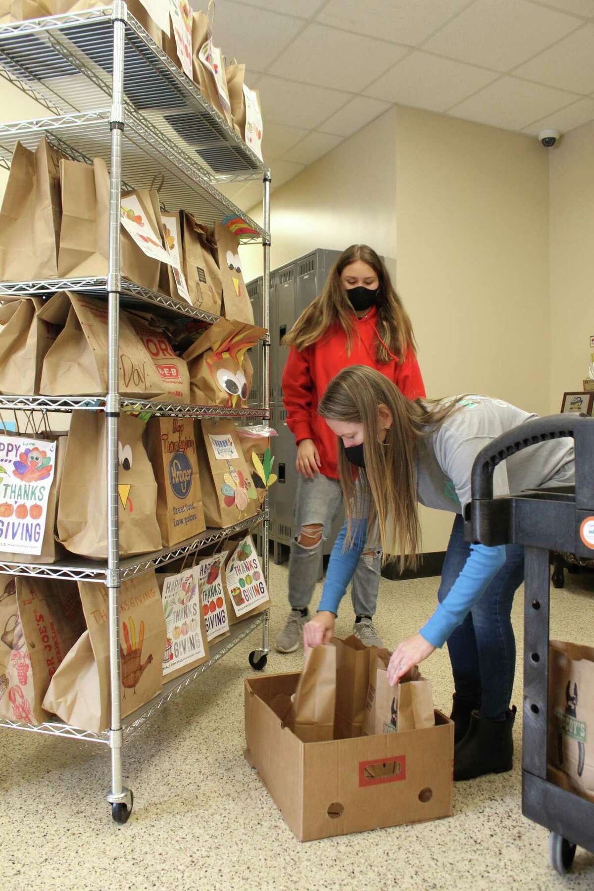 This year, Meals on Wheels Montgomery County will be delivering 692 meal bags to clients on Thanksgiving. Rylan and Misti Burgess, volunteers with the National Charity League Montgomery Monarchs, sort the Thanksgiving meal bags on Nov. 24, 2020.