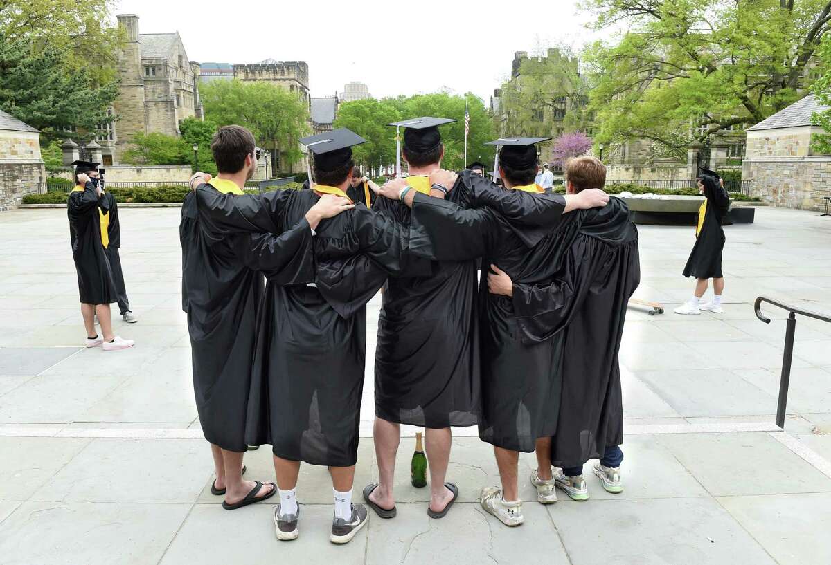 Yale University graduates pose for photographs on Cross Campus in New Haven on what would have been their commencement on May 18, 2020. Yale University President Peter Salovey delivered an address and conferred degrees via YouTube.