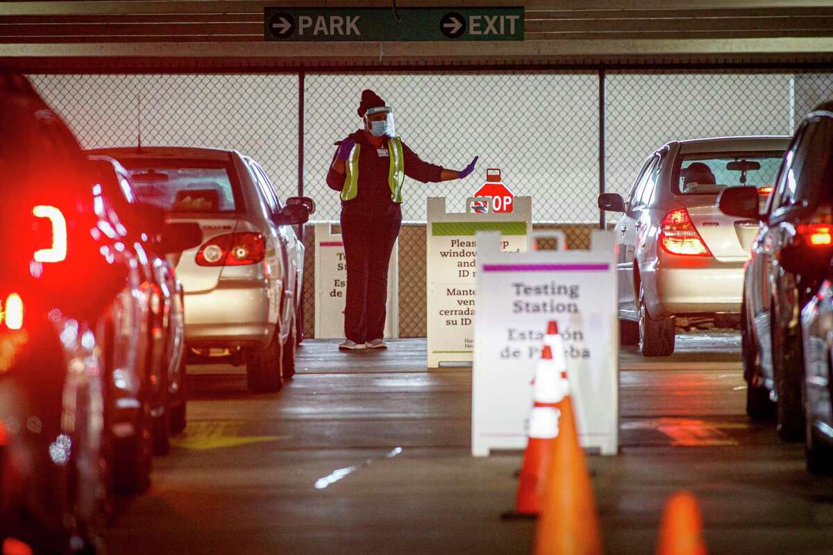 Medical staff work at a COVID-19 testing site at the Connecticut Convention Center in Hartford, Conn., on Wednesday, Nov. 11, 2020. An increase in demand for coronavirus testing in advance of Thanksgiving has led to hours-long lines across Connecticut as providers scramble to add capacity and hire new workers. (Mark Mirko/Hartford Courant via AP)