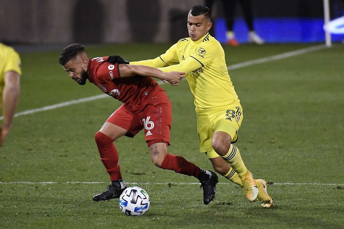 Randall Leal (right) pressures Toronto FC’s Auro Jr. in expansion Nashville’s surprise playoff win.