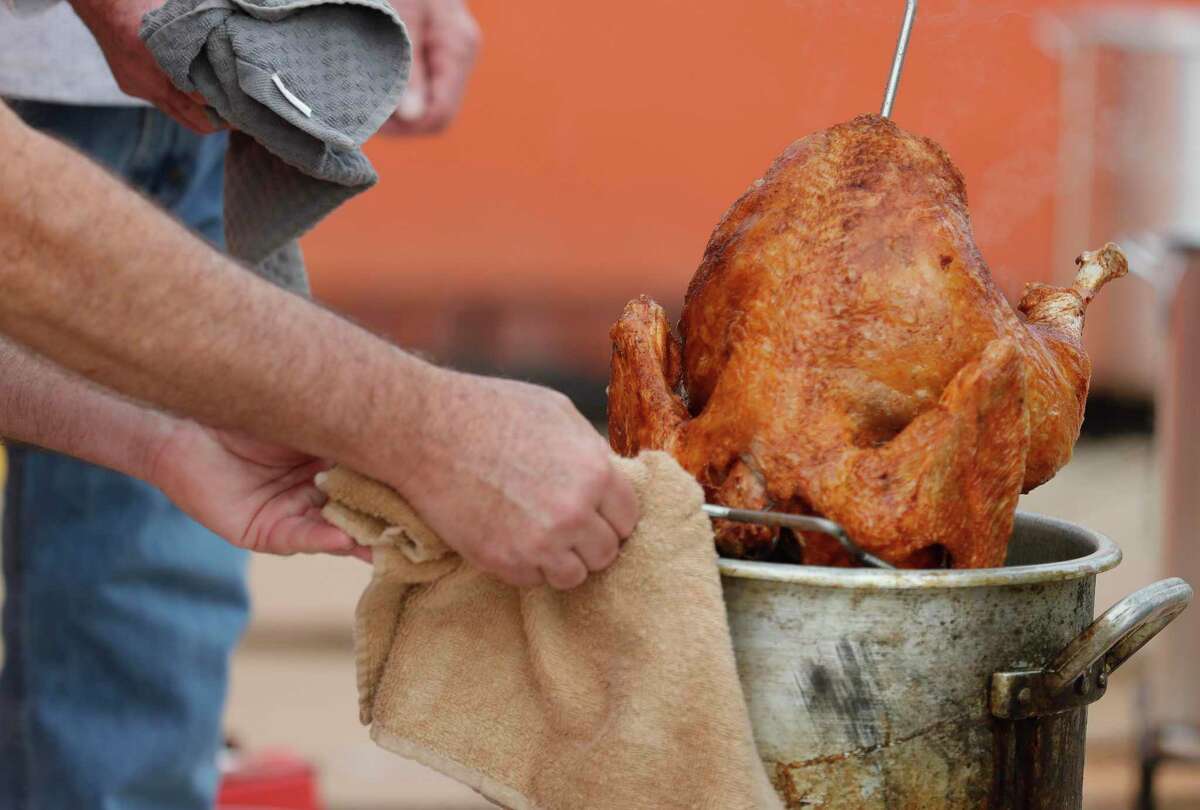Paul McKelvey takes out a freshly fried turkey at The Abundant Harvest, Wednesday, Nov. 25, 2020, in Spring. Saint Isidore Episcopal Church hosted a turkey fry fundraiser with 30 turkeys and recently opened its cafe to company the organziation’s kitchen and food pantry outreach.
