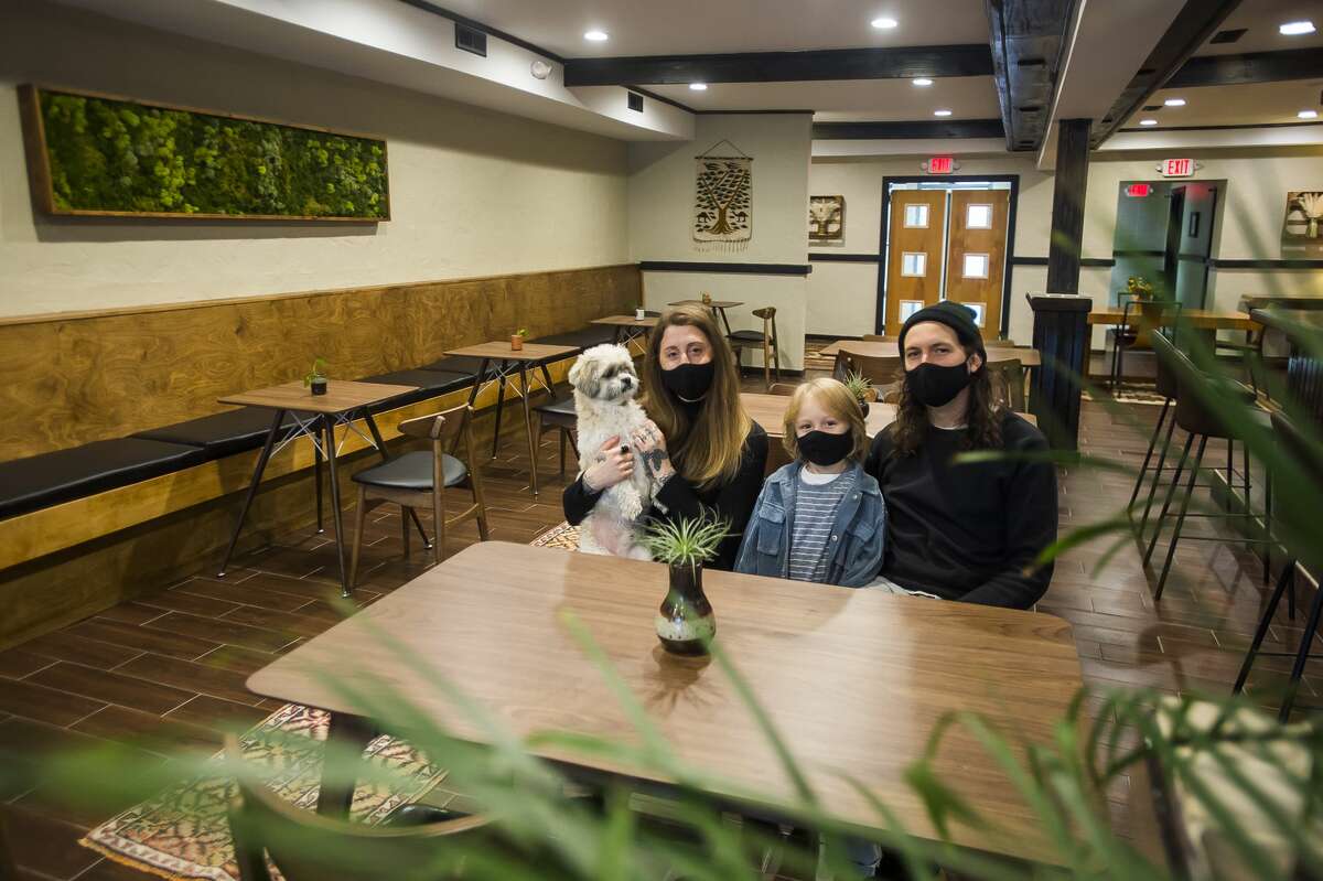 Lisa Kuznicki, left, Evan Sumrell, right, and their son Stanley, center, pose for a portrait Wednesday, Nov. 25, 2020 inside Aster, the family's new farm-to-table restaurant located at 134 Ashman St. in downtown Midland. (Katy Kildee/kkildee@mdn.net)
