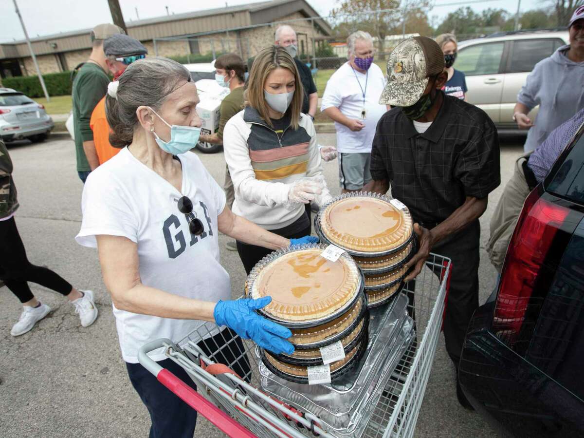 BJ Bradley, left, helps offload pies with Keely Brewer for the annual Friends Feeding Friends Thanksgiving meal, Thursday, Nov. 26, 2020, in Conroe. Volunteers handed out 1,500 meals to community members. This year's event is set for 10:30 a.m. to 1:30 p.m. a three locations. 