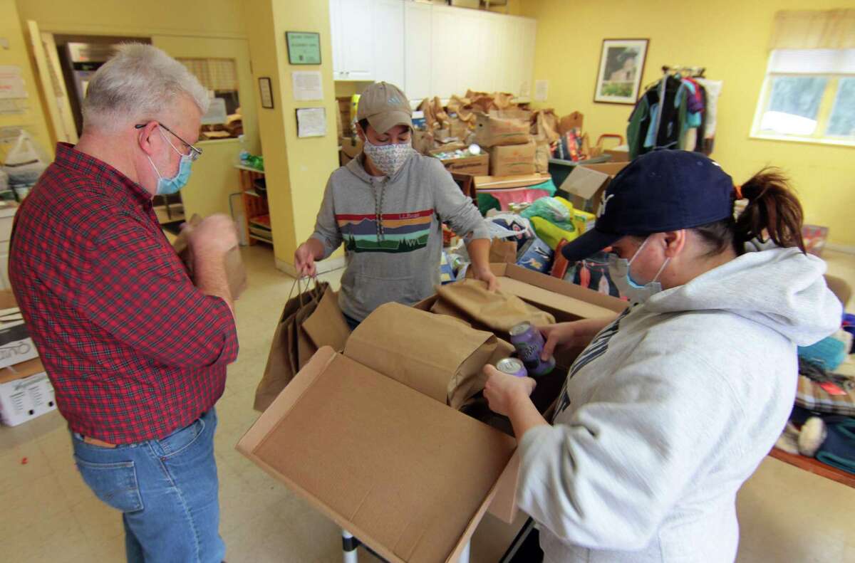 Volunteers at Beth-El Center, Inc. give out Thanksgiving Day dinners families and people in need in Milford, Conn., on Thursday Nov. 26, 2020. A traditional Thanksgiving dinner of turkey, stuffing and side dishes were prepared and donated by Dockside Brewery in Milford. Volunteers from Devon Rotary Club were also on hand to help out. “In a year unlike any other year, it’s really important that we do take time to celebrate, and that we recognize that it is a special day to bring people together around it,” Beth-El Center Executive Director Jenn Paradis said.