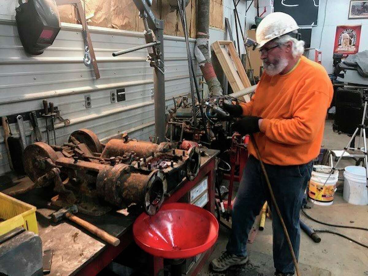 Mike Oberloier of Beaverton works on the 1901 "type O" Thew model steam-powered shovel's swing/travel motor in his home machine shop in Beaverton. (Photo provided/Mike Oberloier)