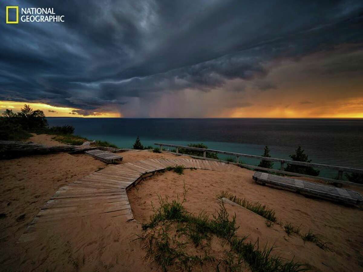 Lake Michigan-As the sun sets, a curtain of rain descends from storm clouds near Sleeping Bear Dunes National Lakeshore on the northeastern coast of Lake Michigan. Of the five Great Lakes, only Lake Michigan lies entirely within the United States. (Keith Ladzinski/National Geographic)