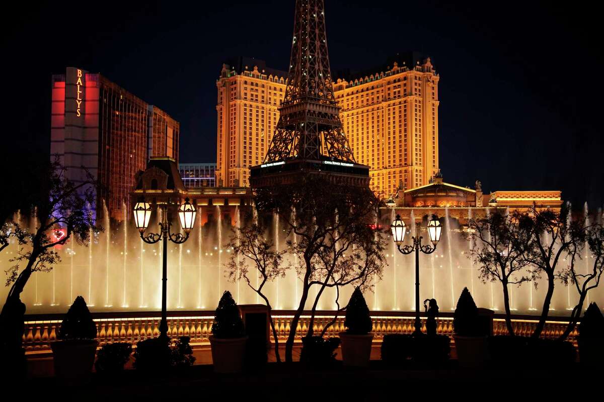 FILE - In this Nov. 19, 2020, file photo, a woman watches the fountains at the Bellagio hotel-casino along the Las Vegas Strip in Las Vegas. Casinos in Nevada reported another month of flat winnings in October, marking a sluggish month in a key index of statewide fiscal health. The Nevada Gaming Control Board said Tuesday, Nov. 24 that casino house winnings of almost $823 million statewide were down 19.5% compared with the same month a year ago, when casinos on a hot streak reported winning more than $1 billion. (AP Photo/John Locher, File)