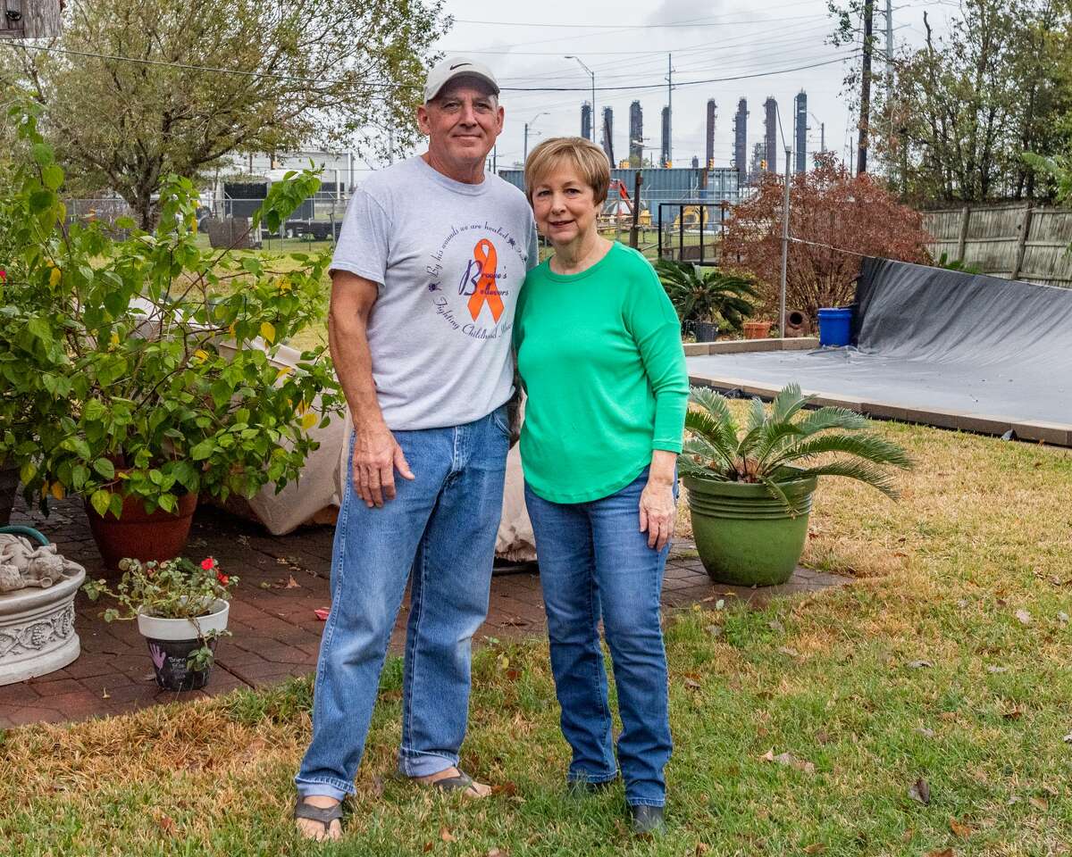 Gary and Susan Miguez stand in the backyard of their home with the towers of the TPC Plant seen over their left shoulders. The plant is about a quarter of a mile from their home and the explosion caused a great deal of structural damage to their home. Port Neches residents are still living with the results of the TPC Group plant explosion one year later. Friday, Nov. 27, marked one year since Port Neches and other surrounding towns in Southeast Texas awoke with a thunderous boom and an orange, glowing sky above their neighborhoods as a chemical plant erupted in flames that burned for the next month. Photo made on November 27, 2020. Fran Ruchalski/The Enterprise
