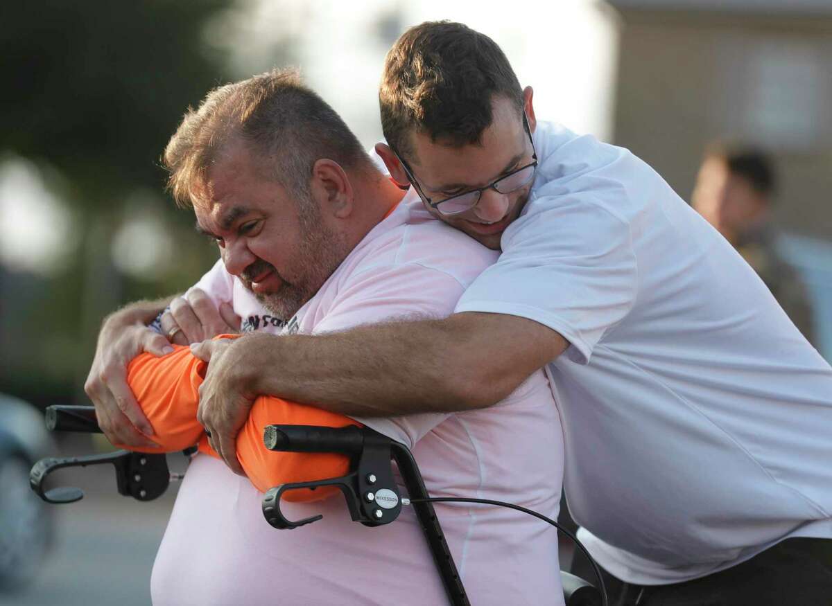 Joe Alvarez, left, gets a hug from his phyiscal trainer Taylor Coibion, owner of The OC Wellness and Fitness, before starting a 5K as he continues to recover from COVID-19 through downtown Conroe, Thursday, Nov. 26, 2020, in Conroe. The Conroe business owner contracted COVID-19 in July and was hospitalized for 32 days on a ventilator and spent time in Houston Methodist Hospital’s COVID ward in Katy.
